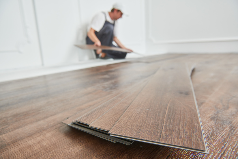 Man installing Luxury Vinyl Plank to make the floor the best waterproof option for the homeowner