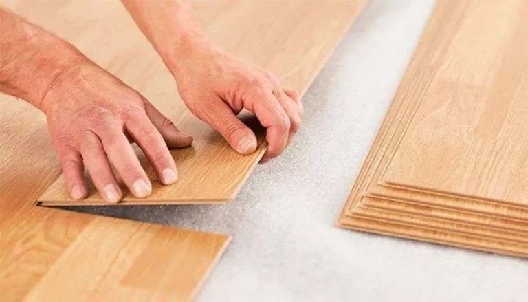 Homeowner placing click-lock planks over an underlayment